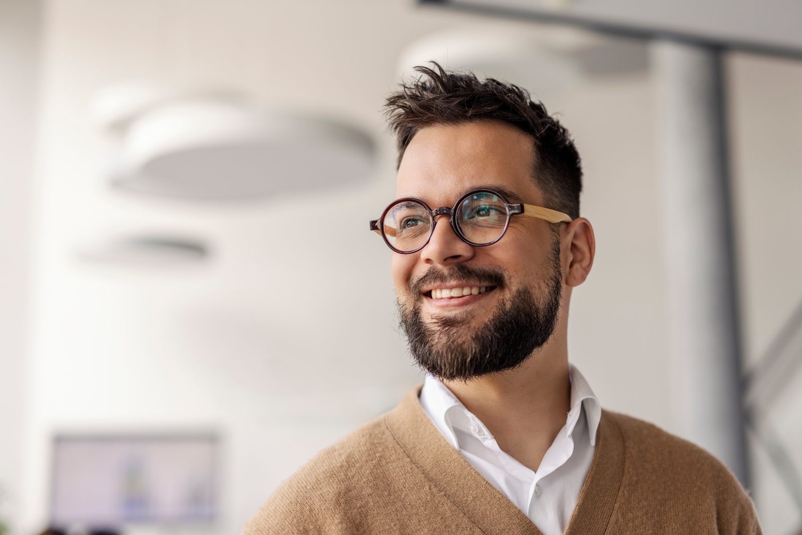 Smiling man wearing glasses in a bright office